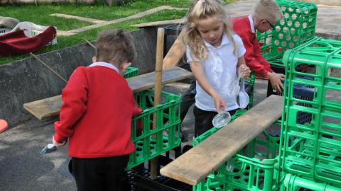 Children building with crates in playground. 