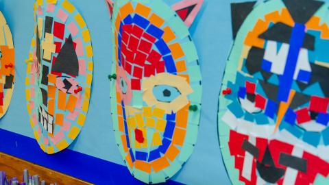 Some homemade masks make a colourful wall display