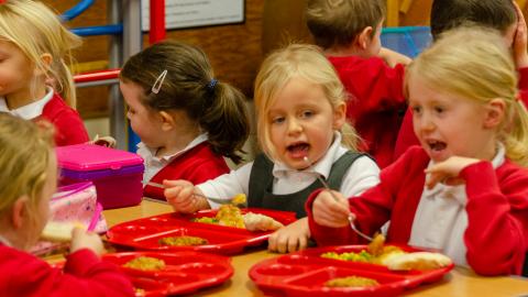 Early years pupils heating their lunch