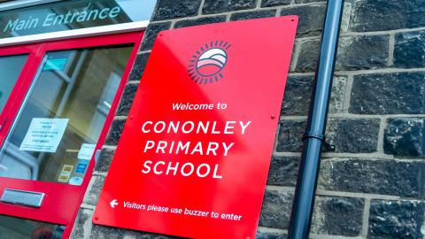 Picture of the main entrance showing a big red sign which reads Cononley Primary School