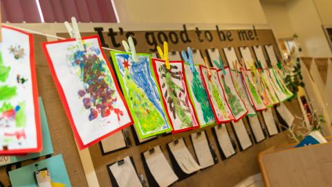 Paintings pegged to a string, strung across the classroom