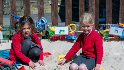 Two girls in the sandpit of the early years playground